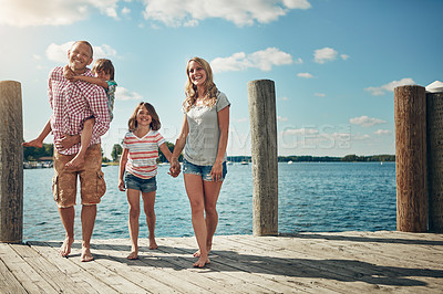 Buy stock photo Shot of a young family on a pier while out by the lake