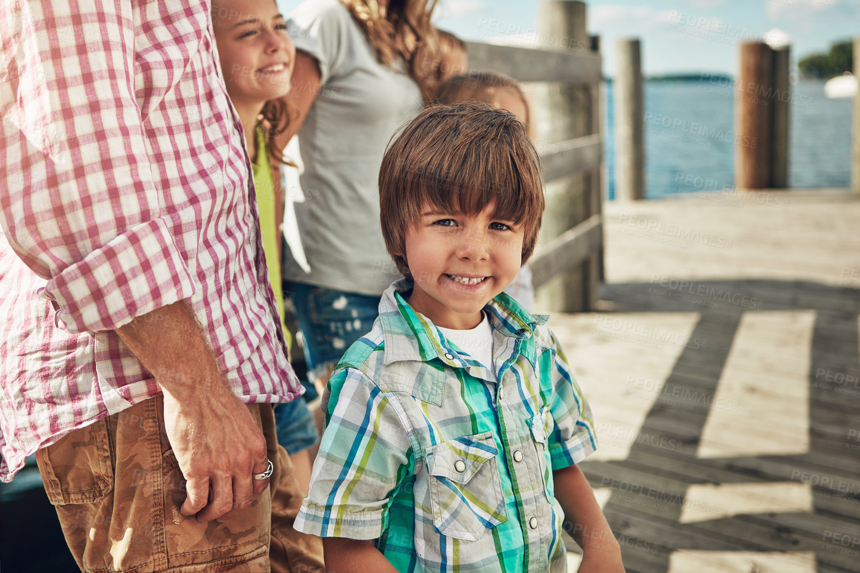 Buy stock photo Shot of a young family on a pier while out by the lake