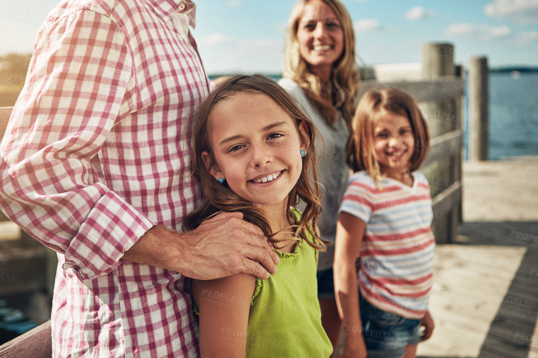 Buy stock photo Shot of a young family on a pier while out by the lake