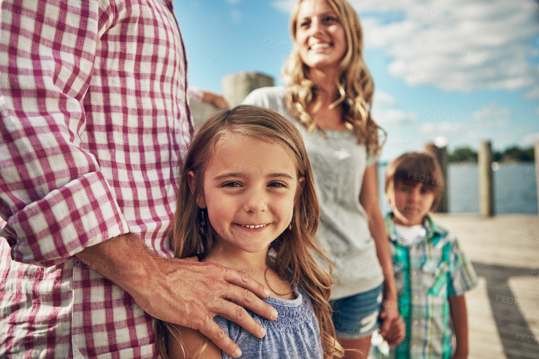 Buy stock photo Shot of a young family on a pier while out by the lake