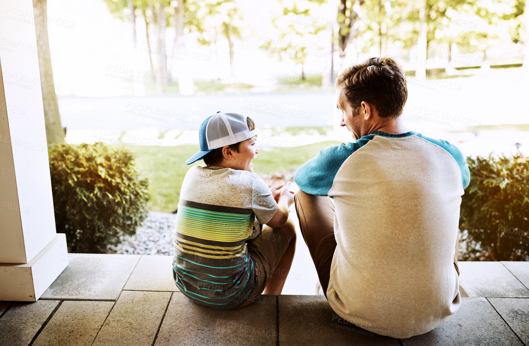 Buy stock photo Rearview shot of a father and his son bonding on their porch at home