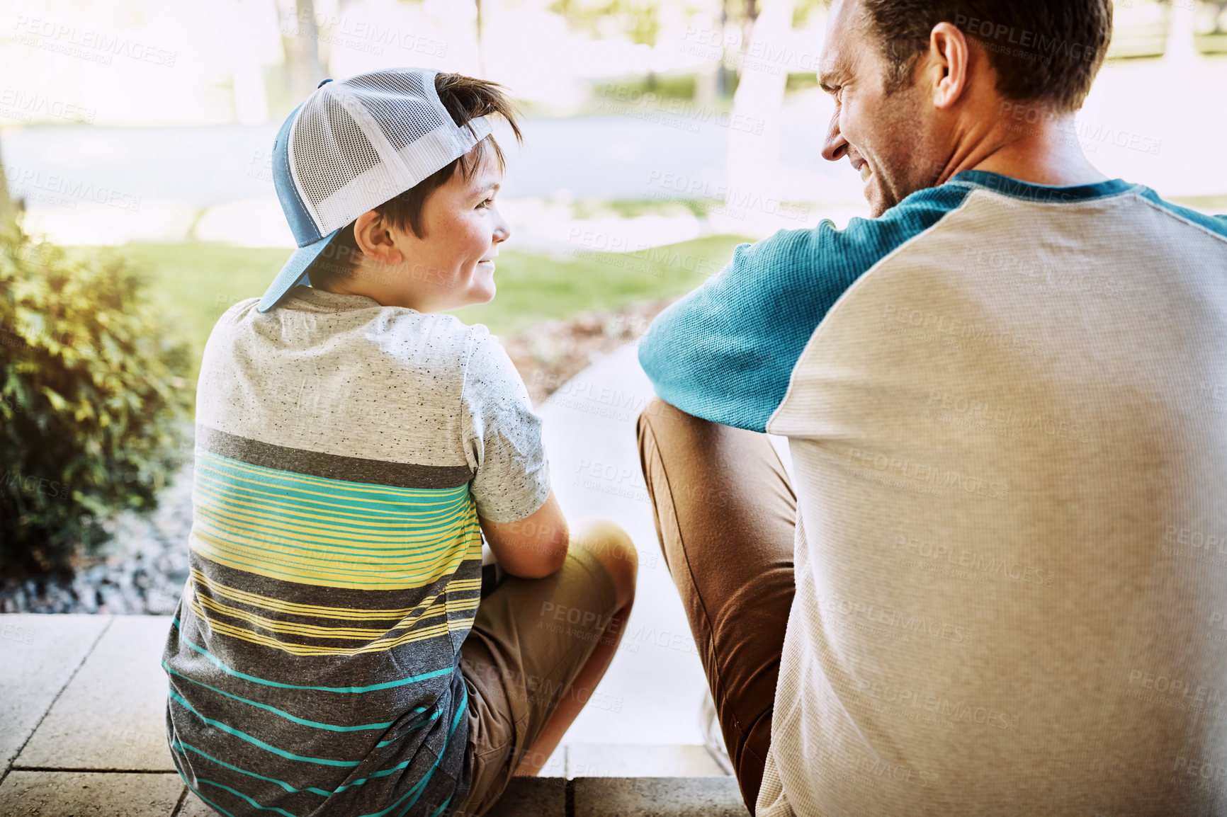 Buy stock photo Rearview shot of a father and his son bonding on their porch at home