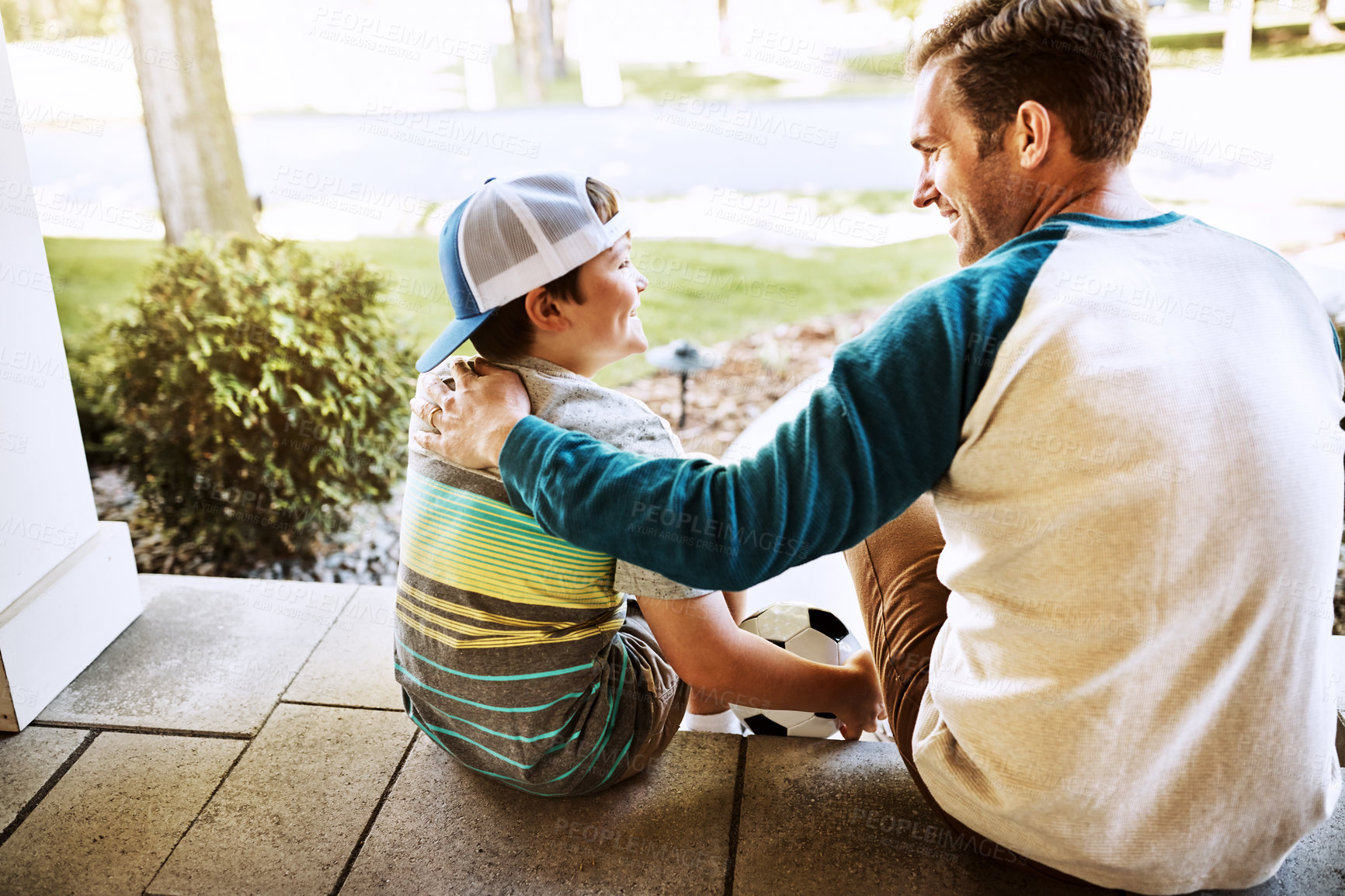 Buy stock photo Rearview shot of a father and his son bonding on their porch at home