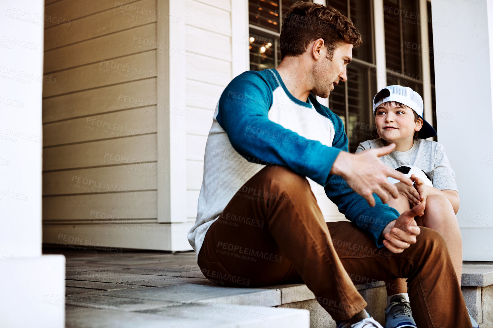 Buy stock photo Shot of a father and his son bonding on their porch at home