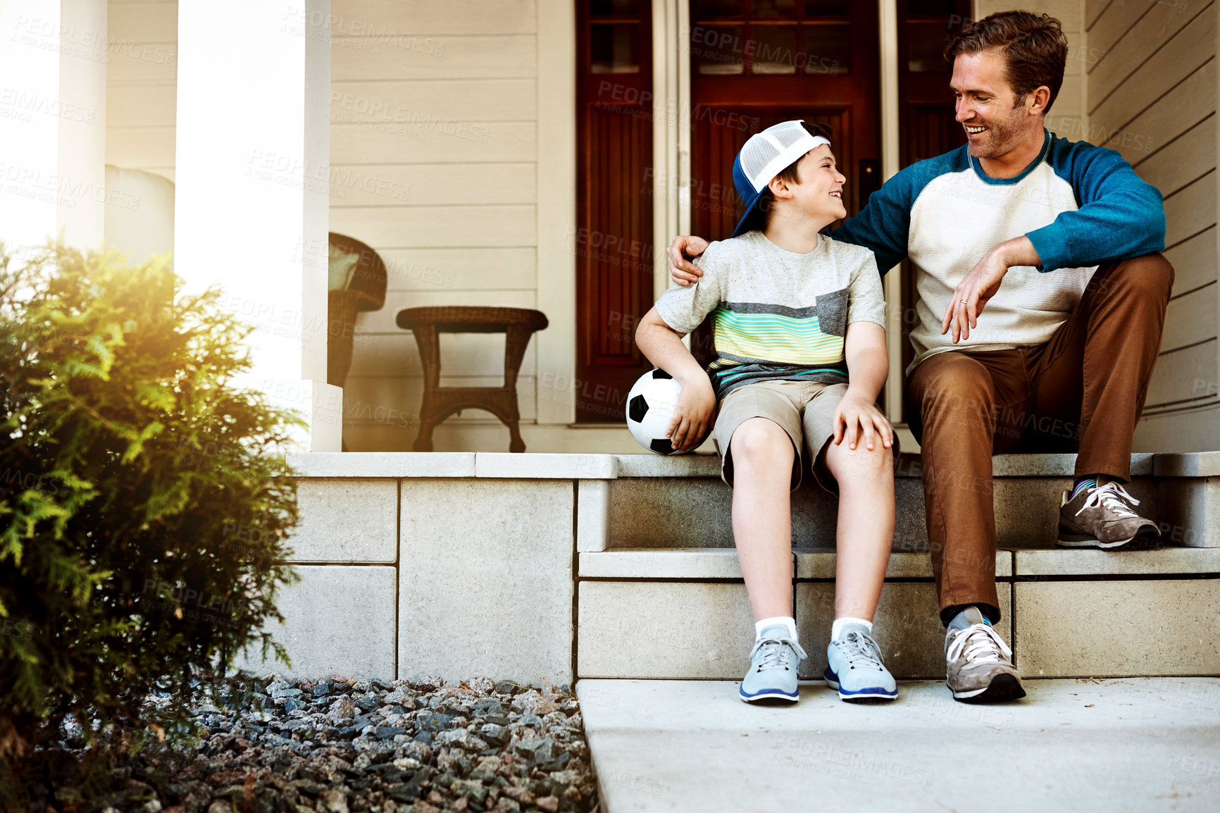 Buy stock photo Shot of a father and his son bonding on their porch at home