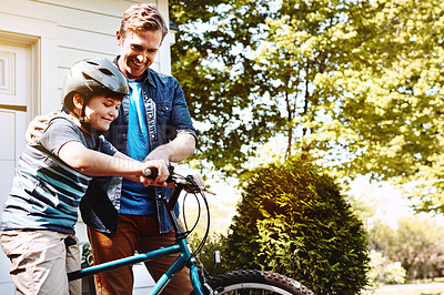 Buy stock photo Shot of a father teaching his son how to ride a bicycle