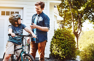 Buy stock photo Shot of a father teaching his son how to ride a bicycle