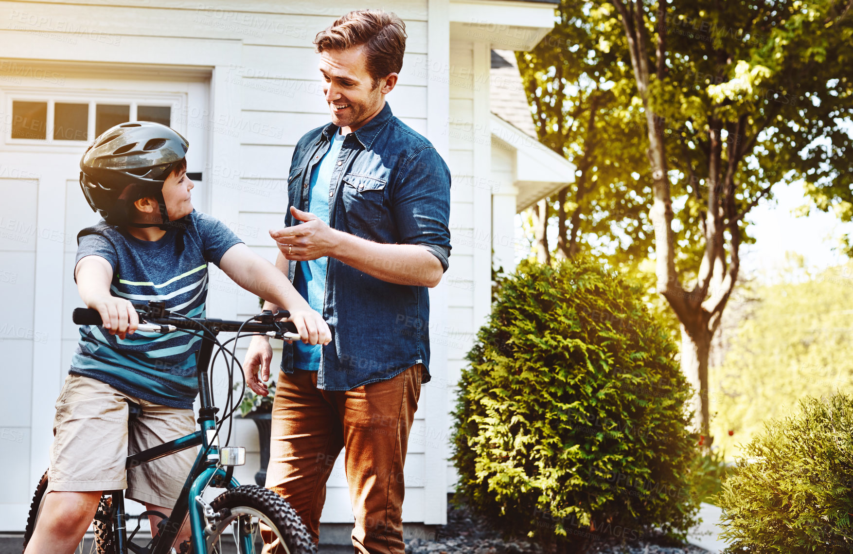 Buy stock photo Shot of a father teaching his son how to ride a bicycle