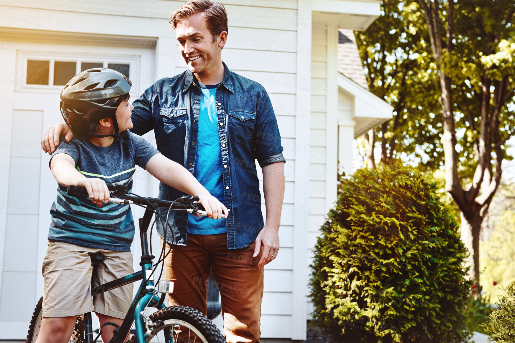 Buy stock photo Shot of a father teaching his son how to ride a bicycle