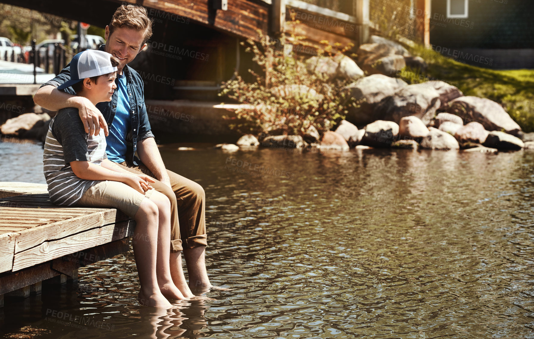 Buy stock photo Lake, father or kid relax on pier for bonding together, weekend break or conversation with trust. Single dad, child or talking on jetty for healthy relationship, affection or family outing with space