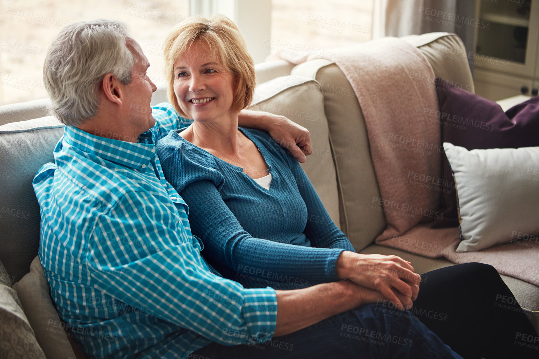 Buy stock photo Love, holding hands and happy senior couple relax on sofa with conversation, trust and support, care or bonding at home together. Smile, calm and old people hug in living room with marriage pride