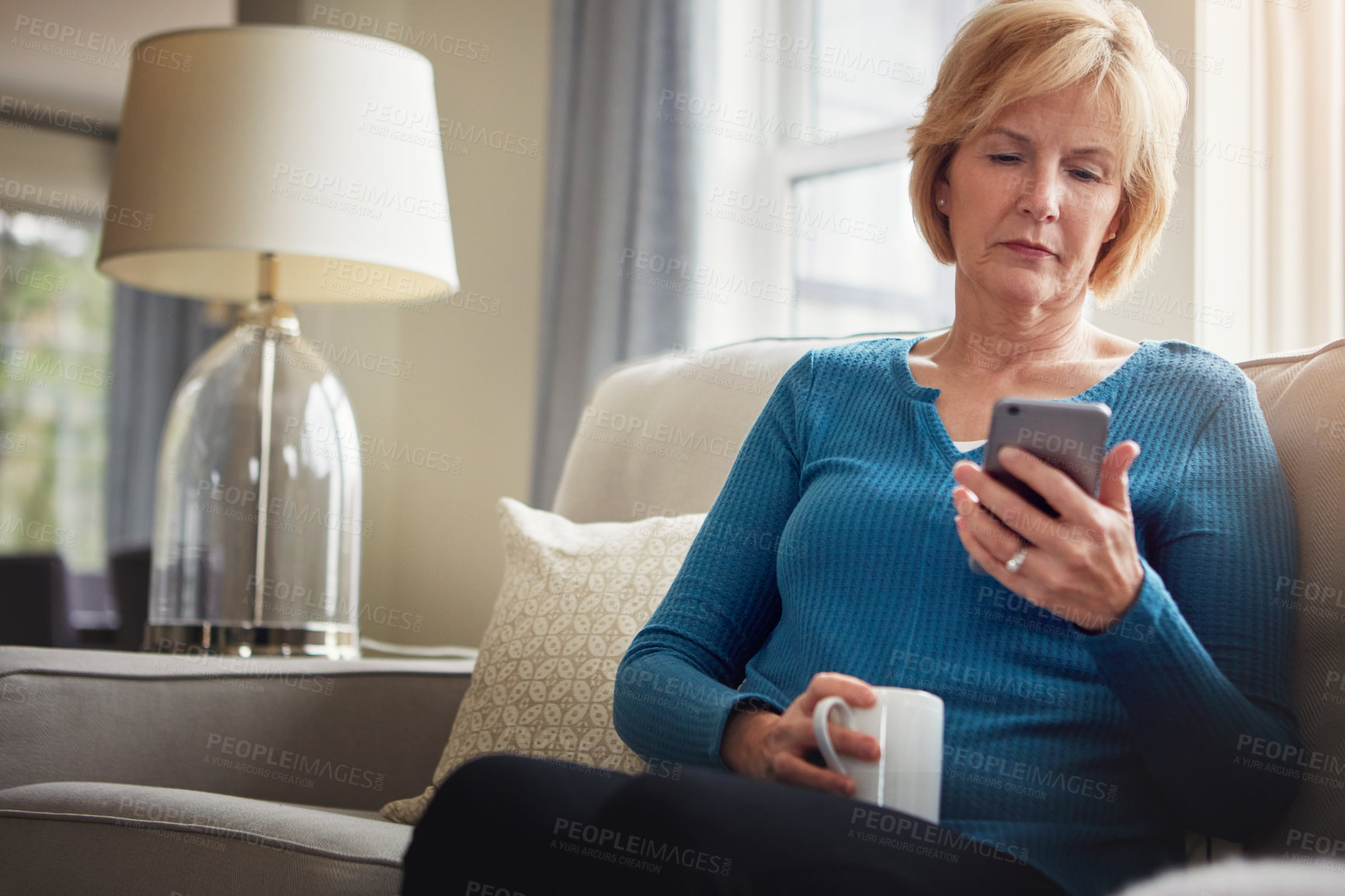 Buy stock photo Home, relax and old woman on sofa with cellphone, typing and connection with coffee in living room. Senior person, apartment or mature lady with smartphone, internet and digital app with social media