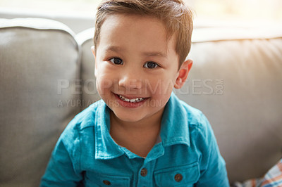 Buy stock photo Cropped portrait of an adorable little boy sitting on the sofa at home