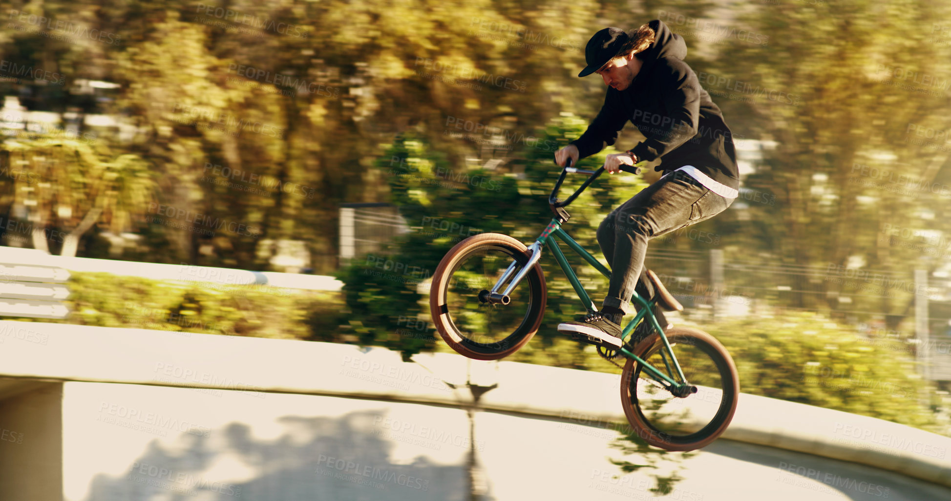 Buy stock photo Full length shot of a young male BMX rider doing tricks around the city