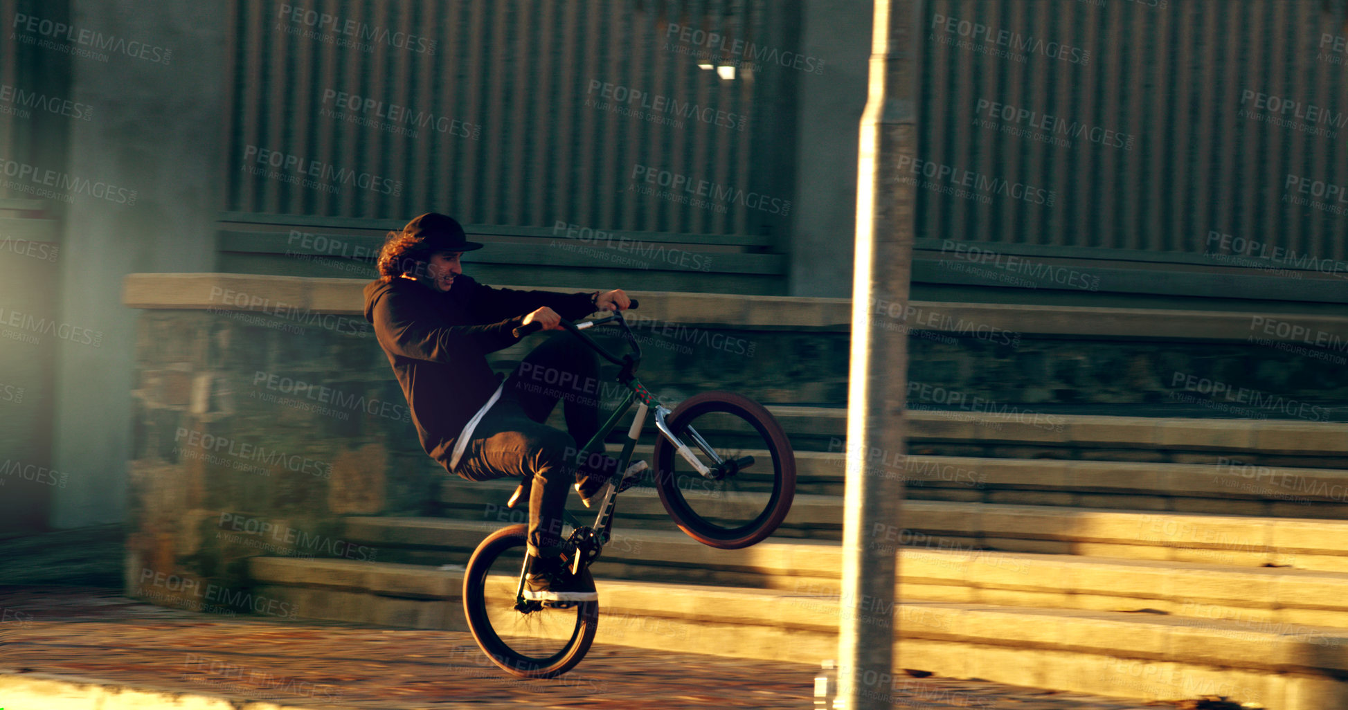 Buy stock photo Full length shot of a young male BMX rider doing tricks around the city