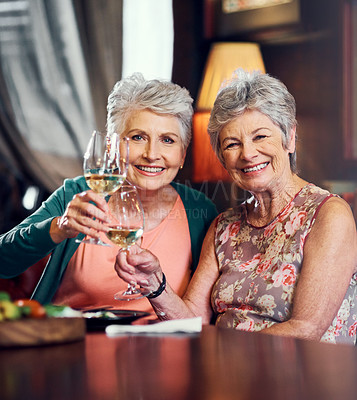 Buy stock photo Cropped portrait of two senior female friends toasting during a lunch date