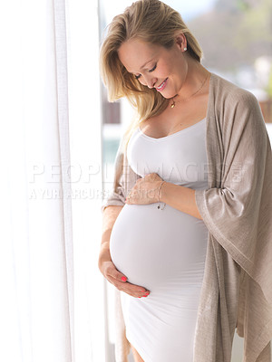 Buy stock photo Cropped shot of a beautiful young pregnant woman standing in her home