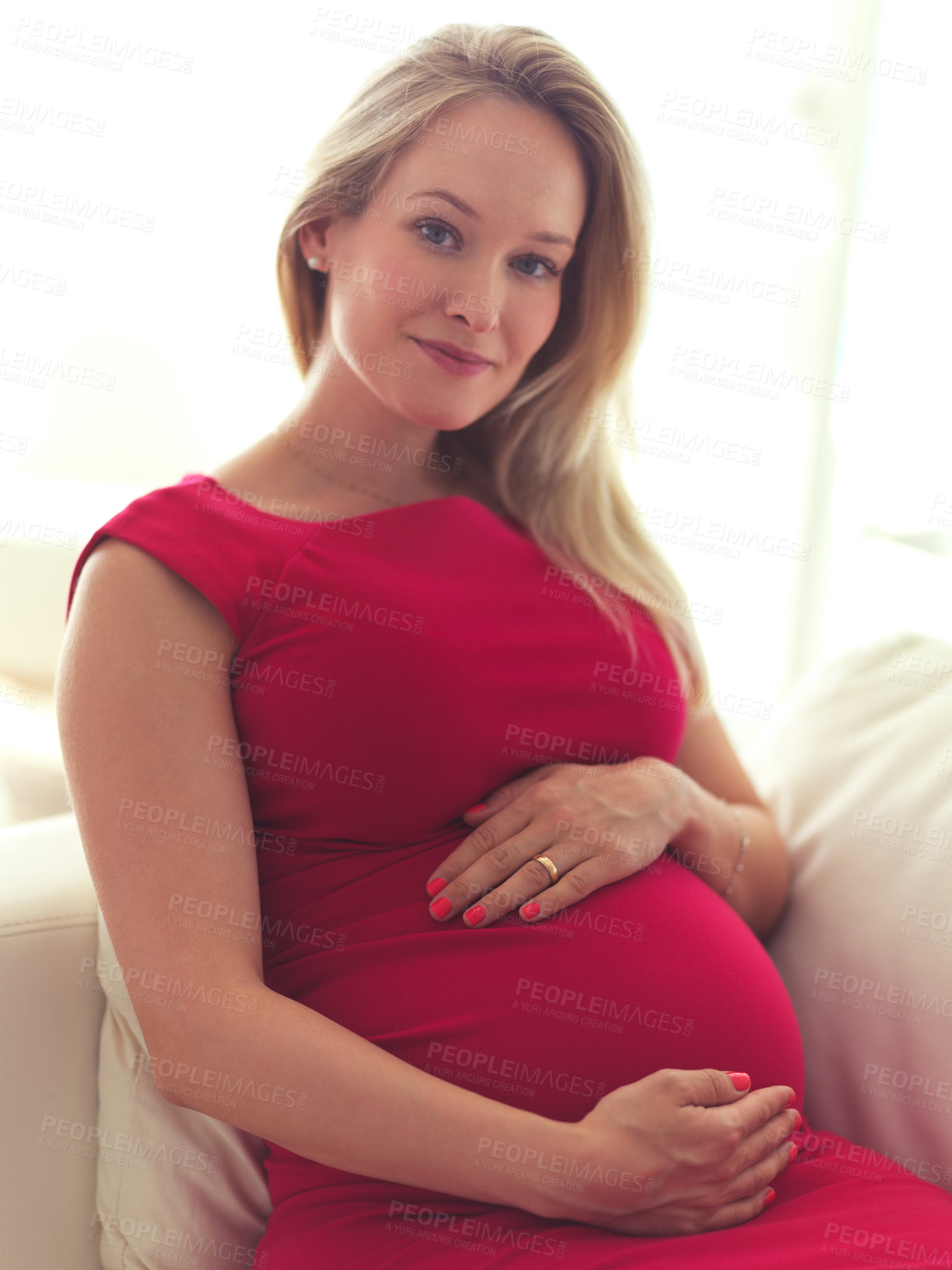 Buy stock photo High angle portrait of a beautiful young pregnant woman sitting on the sofa at home