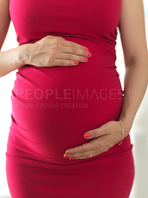 Buy stock photo Cropped shot of an unrecognizable pregnant woman standing in her home