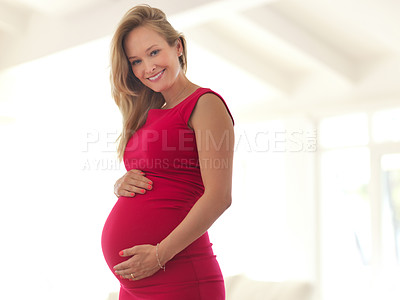 Buy stock photo Low angle portrait of a beautiful young pregnant woman standing in her home
