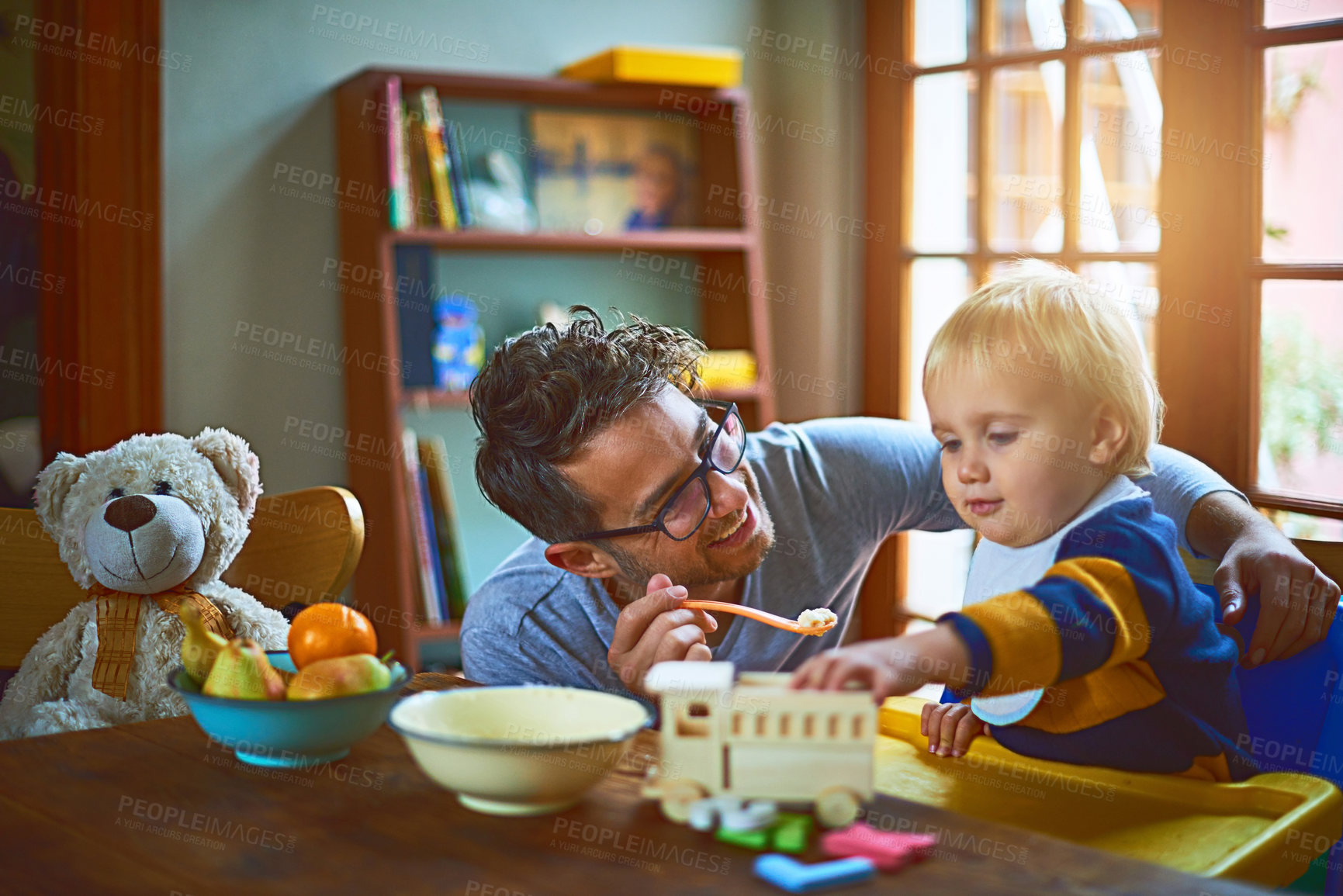 Buy stock photo Cropped shot of a single father feeding his son at home