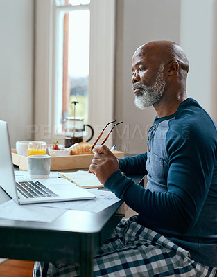 Buy stock photo Shot of a senior man using a laptop at home