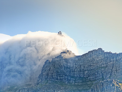 Buy stock photo Landscape view of a cloud covering a mountain peak with copy space on Table Mountain in Cape Town, South Africa. Blue sky, rough, rocky terrain on famous landmark with cloudscape. Travel and tourism