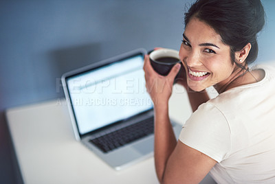 Buy stock photo High angle portrait of an attractive young businesswoman drinking coffee while working on a laptop in her office