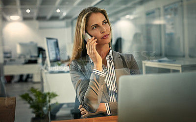 Buy stock photo Shot of a businesswoman talking on her phone during a late shift at work