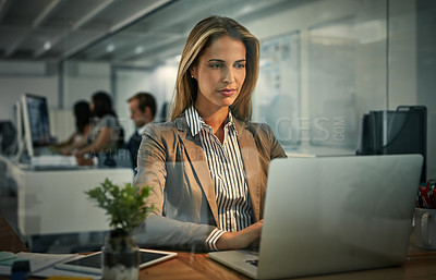 Buy stock photo Shot of a businesswoman using a laptop during a late shift at work