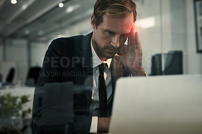 Buy stock photo Shot of a businessman looking stressed while working at his laptop