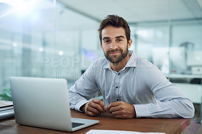 Buy stock photo Portrait of a young corporate businessman sitting in front of a laptop in an office