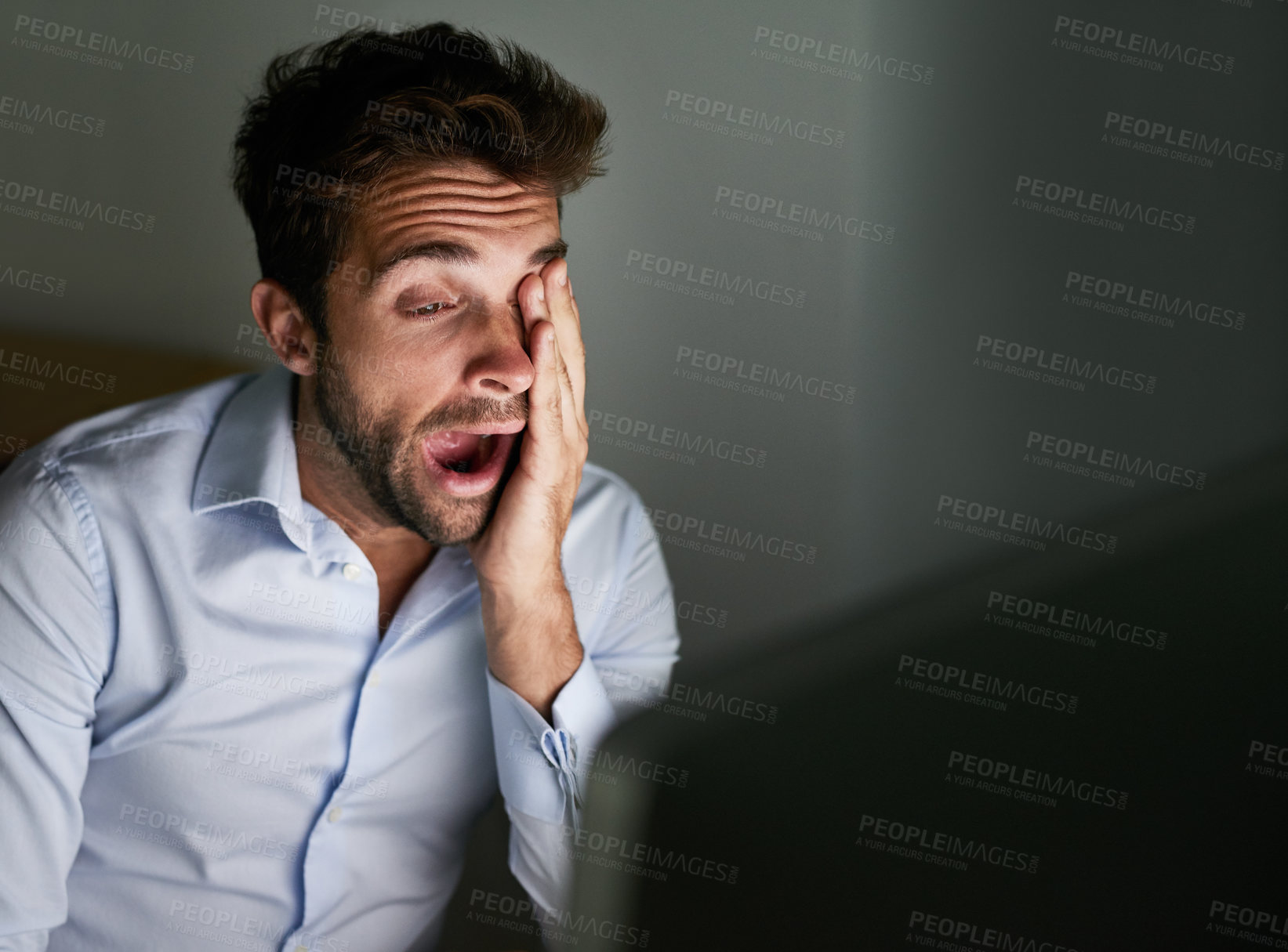 Buy stock photo Shot of a young businessman working late at the office 