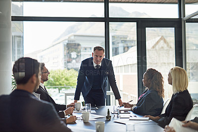 Buy stock photo Presentation, man speaker with coworkers and in business meeting in a conference room of their workplace. Brainstorming or planning, ideas or data review and colleagues together in modern office