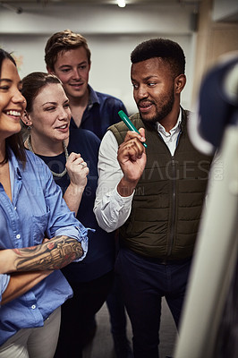 Buy stock photo Shot of a group of designers brainstorming on a whiteboard in an office