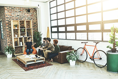 Buy stock photo Shot of a group of young designers having a discussion in a modern office
