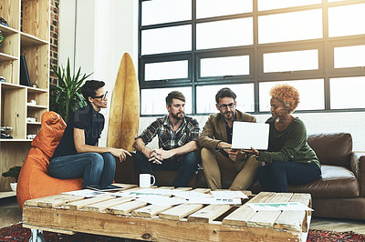 Buy stock photo Shot of a group of designers using a laptop in their brainstorming session