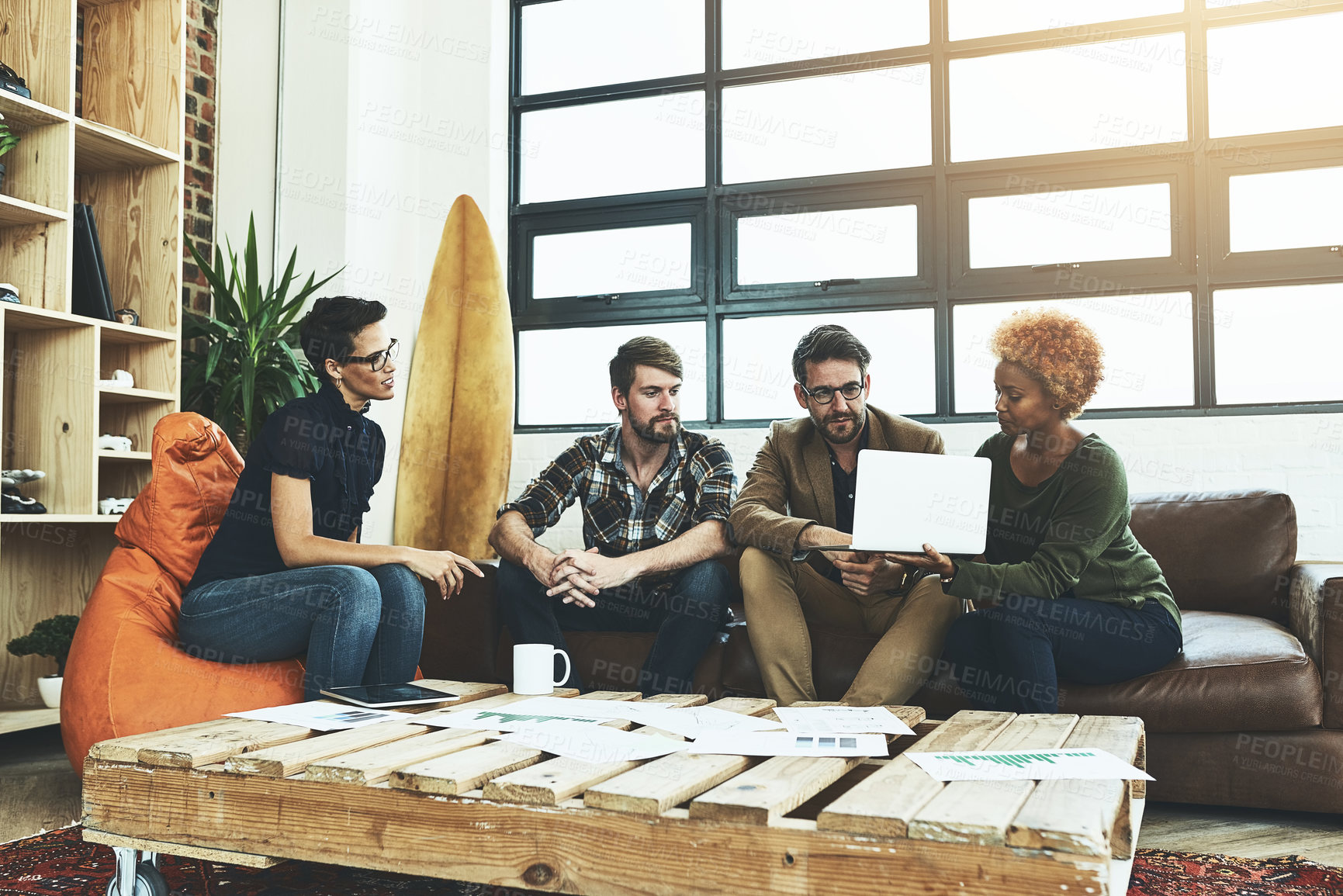 Buy stock photo Shot of a group of designers using a laptop in their brainstorming session