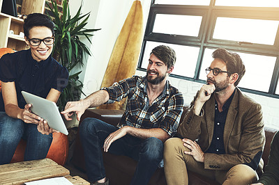 Buy stock photo Shot of a group of designers using a tablet in their brainstorming session