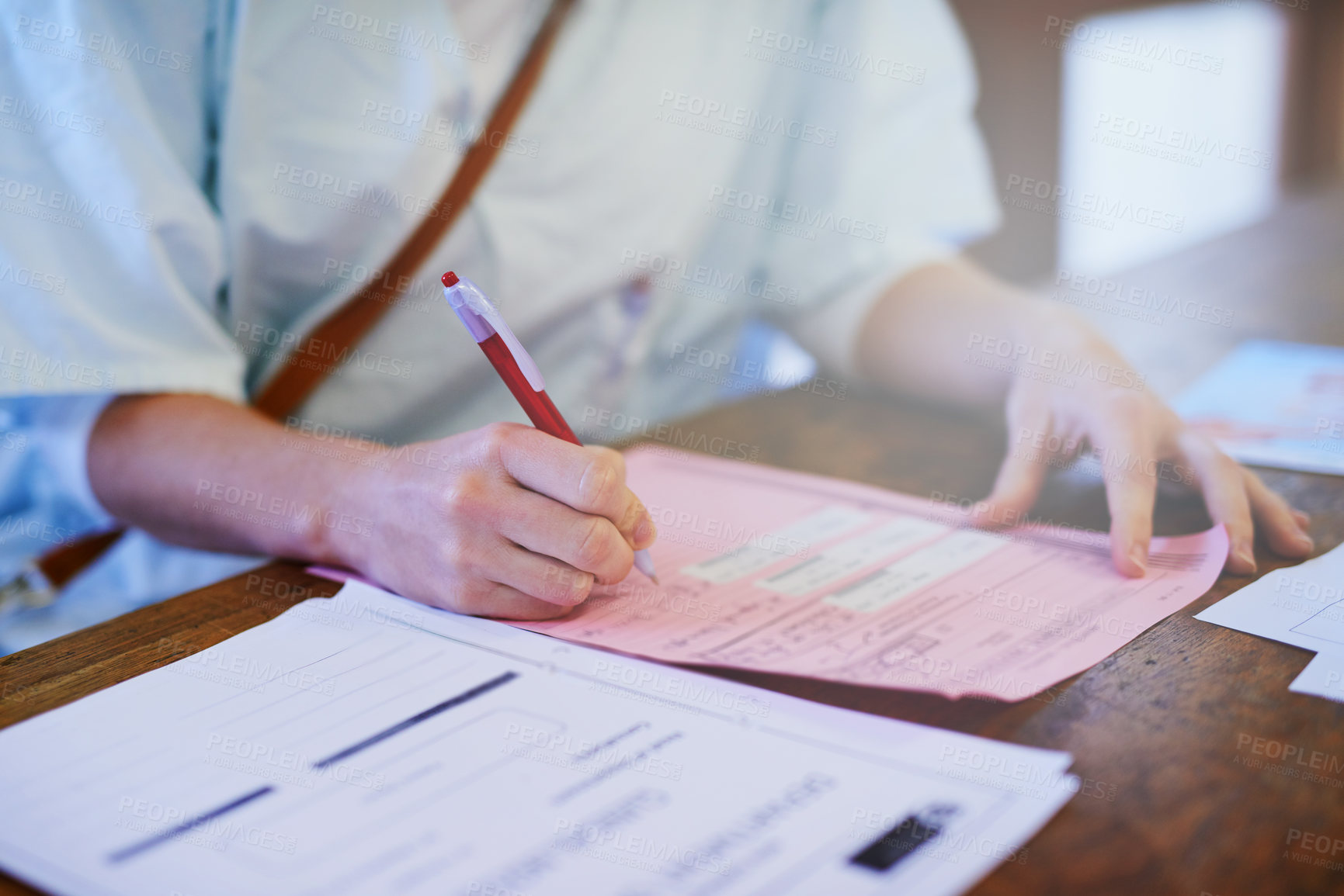 Buy stock photo Cropped shot of a doctor filling out paperwork in a hospital