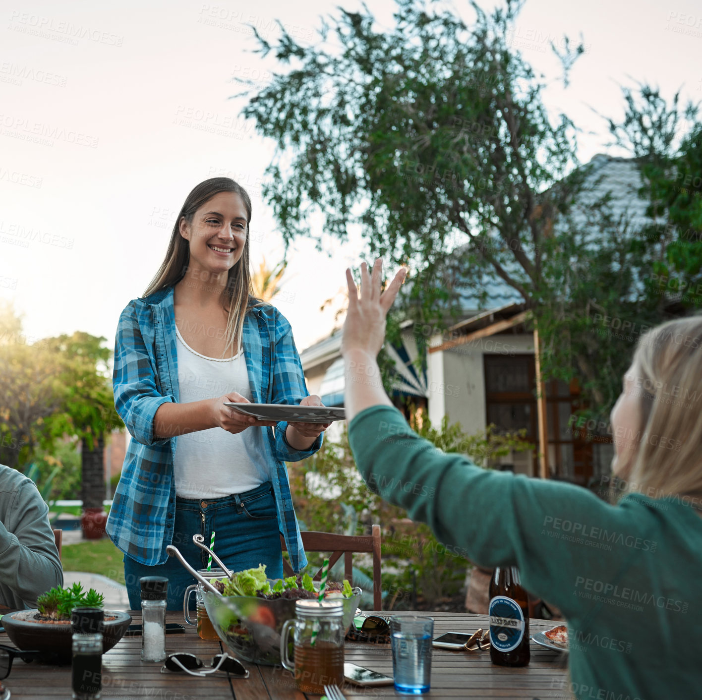 Buy stock photo Serving, barbecue and friends in backyard of home for social event, hang out or gathering with dinner. Happy, offer and women with raised hand for food at grill supper in outdoor garden of house.