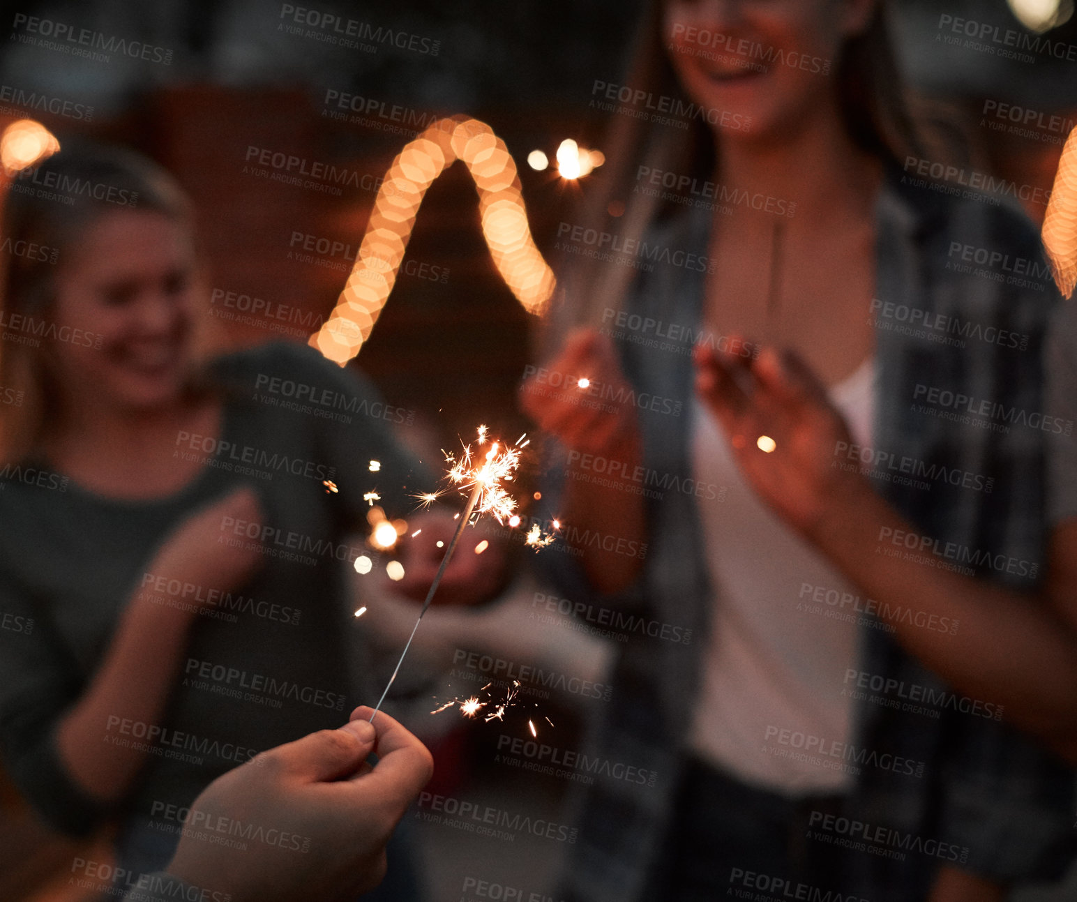 Buy stock photo Hands, sparkle and people with glow outdoor for celebration, light and success of new years party. Happy, friends and fireworks with flame shine, announcement and achievement memory at night together