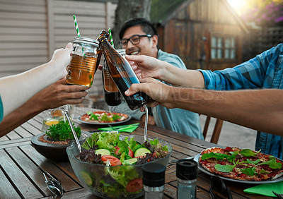 Buy stock photo Shot of a group of young friends holding up drinks and toasting outside around a table to celebrate their friendship