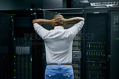 Buy stock photo Rearview shot of an IT technician having difficulty repairing a computer in a data center
