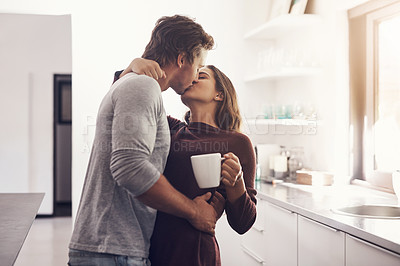 Buy stock photo Love, intimate and kiss with a couple in the kitchen of their home together in the morning for romance. Kissing, passion or sexy with a man and woman in their house for romantic intimacy or bonding