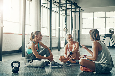 Buy stock photo Shot of a group of young women taking a break together after a workout at the gym
