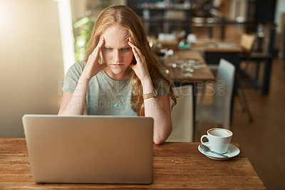 Buy stock photo Cropped shot of a young woman looking stressed while sitting in front of her laptop