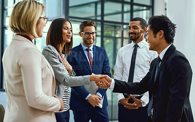 Buy stock photo Shot of businesspeople shaking hands in an office
