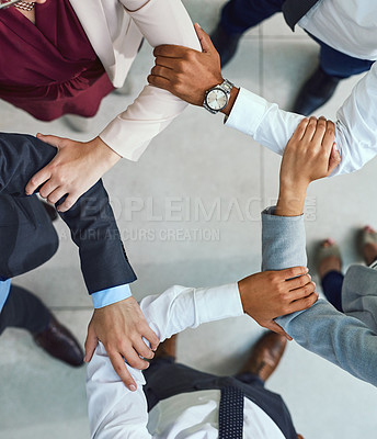 Buy stock photo High angle shot of a group of unrecognisable businesspeople joining their hands together in unity