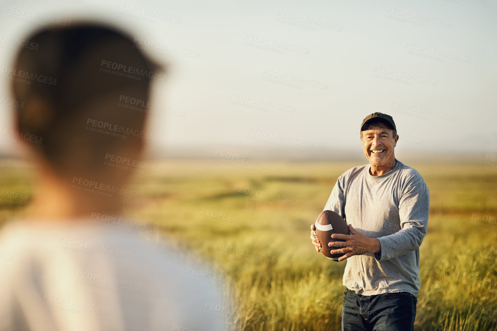 Buy stock photo Kid, man and football with teaching in nature for outdoor adventure, happiness and child development. Smile, dad and sports with son on grass field for exercise, practice and bonding on fathers day